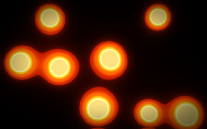Glowing orange blobs with pale yellow middles on a black picture, two pairs of them melting into each other, like a lava lamp